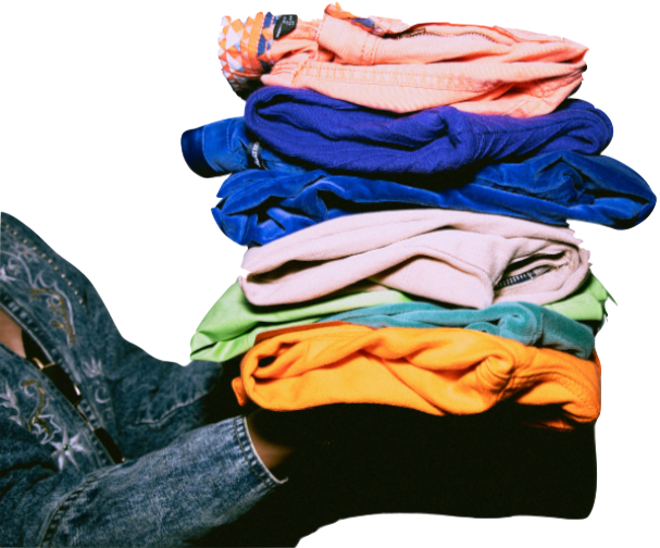A tall stack of colourful folded clothes carried in one arm